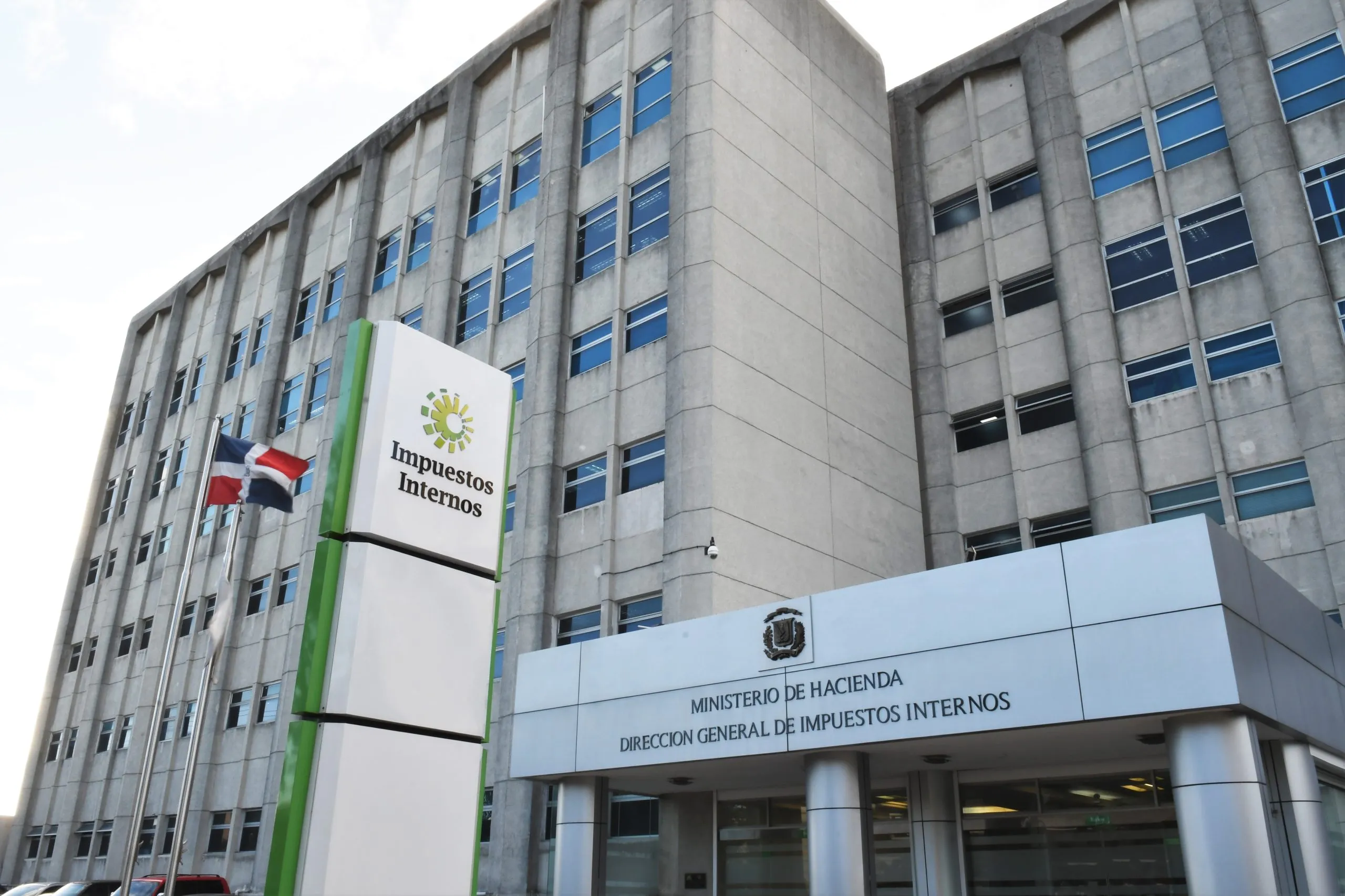Sede de la Dirección General de Impuestos Internos, con el letrero de Impuestos Internos y la bandera dominicana frente al edificio